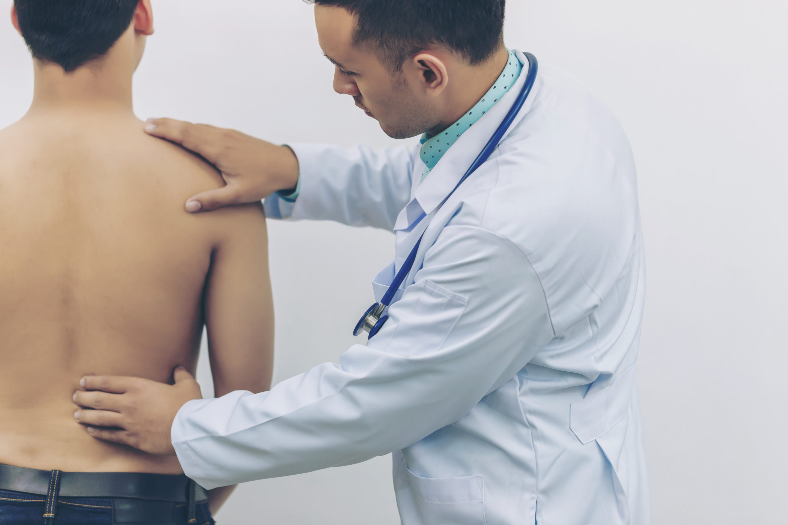 Doctor Touches The Back Plate For Causes Of Back Pain With Stethoscope 